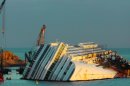The cruise ship Costa Concordia, leaning on its side, is seen just off the coast of the Tuscan island of Giglio, Italy, Saturday, Jan. 12, 2013. As if the nightmares, flashbacks and anxiety weren't enough, passengers who survived the terrifying grounding and capsizing of the Costa Concordia off Tuscany have come in for a rude shock as they mark the first anniversary of the disaster on Sunday. Ship owner Costa Crociere SpA, the Italian unit of Miami-based Carnival Corp., sent several passengers a letter telling them they weren't welcome at the official anniversary ceremonies on the island of Giglio where the hulking ship still rests. Costa says the day is focused on the families of the 32 people who died Jan. 13, 2012, not the 4,200 passengers and crew who survived. (AP Photo/Paolo Santalucia)