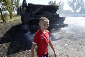A boy walks by a burnt army truck on September 7, 2014&nbsp;&hellip;