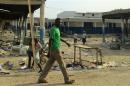 A man walks past burnt-out shops in Malakal