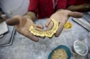 worker holds a gold necklace at a gold workshop in the city of Isfahan