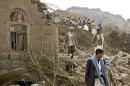 FILE - In this Saturday, April 4, 2015 file photo, Yemenis stand amid the rubble of houses destroyed by Saudi-led airstrikes in a village near Sanaa, Yemen. Since their advance began last year, the Shiite rebels, known as Houthis have overrun Yemen's capital, Sanaa, and several provinces, forcing the country's beleaguered President Abed Rabbo Mansour Hadi to flee the country. A Saudi-led coalition continued to carry out intensive airstrikes overnight and early Saturday morning targeting Houthi positions. (AP Photo/Hani Mohammed, File)