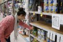 A woman browses for milk powder at a stand with a food recall notice from Nutricia in a supermarket in Huntly