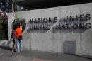 Tourists observe a logo at the United Nations European headquarters in Geneva