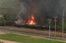 Flames are seen where a CSX Corp train carrying crude oil derailed and burst into flames in downtown Lynchburg