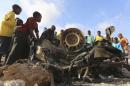 Somali children crowd around wreckage of car that exploded in front of City Palace hotel on Friday night, leaving one injured, in Mogadishu