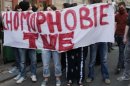 File photo of French student Clement Meric who wears a red scarf over his face as he walks near a banner to support France's planned legalisation of same-sex marriage in Paris