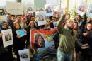 Protesters hold protraits of Iraqi female journalist Afrah Shawqi during a demonstration calling for her release on December 30, 2016, in Baghdad