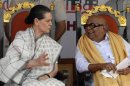 Sonia Gandhi speaks with M. Karunanidhi during an election campaign rally in Chennai