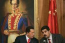 FILE .- In this Oct. 17, 2006 file photo Venezuelan President Hugo Chavez, left, talks with his then Foreign Minister and current Vice-President Nicolas Maduro during a meeting with Chinese businessmen at Miraflores Palace in Caracas, Venezuela. Chavez is to return to Cuba Sunday for another surgery in his battle against cancer, which has led him to speak publicly of a successor for the first time. Chavez said Saturday that if there are "circumstances that prevent me from exercising the presidency further" Vice-President Nicolas Maduro should replace him for the remainder of his term. (AP Photo/Fernando Llano, File)