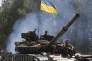 Ukrainian soldiers ride on a tank as they patrol area near eastern Ukrainian town of Debaltseve