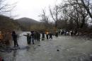 Refugees and migrants cross a river near the Greek-Macedonian border to return to Greece, after an unsuccessful attempt to enter Macedonia, west of the village of Idomeni, Greece