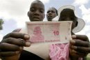A woman displays a new Z$10 banknote in Harare