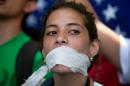 A demonstrator covers her mouth with a rag to prostest government censorship, during a march to Venezuelan Telecommunications Regulator Office or CONATEL in Caracas, Venezuela, Monday, Feb17, 2014. Students, who've spent the past week on the streets alternating between peaceful protests by day and battles with police at night, marched on Monday to Venezuela's telecom regulator to demand it lift all restrictions on the media's coverage of the unfolding political crisis. (AP Photo/Alejandro Cegarra)