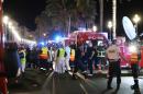 Police officers, firefighters and rescue workers are seen at the site of an attack on July 15, 2016, after a truck drove into a crowd watching a fireworks display in the French Riviera town of Nice