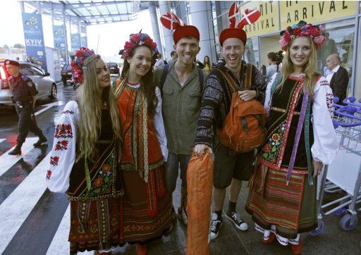 Fans of Sweden's national soccer team take pictures with Ukrainian girls, dressed in traditional clothes in Kiev's airport