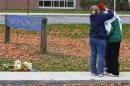 Kelly McLean hugs her son Brandon after leaving flowers outside Danvers High School in Boston