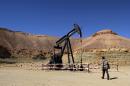 A Libyan security member walks by an oil drill on March 23, 2013 near the city of Waddan