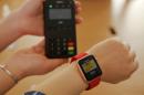 FILE PHOTO : An employee uses an Apple Watch to demonstrate to reporters how to pay using the Apple Pay service at an Apple store in Beijing