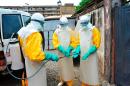 Medical staff clean their protection suits as part of the fight against the Ebola virus on March 8, 2015 at the Donka hospital in Conakry