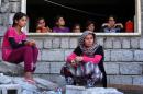 Iraqi Yazidi women who fled the violence in the northern Iraqi town of Sinjar sit at a school where they are taking shelter in the Kurdish city of Dohuk on August 5, 2014