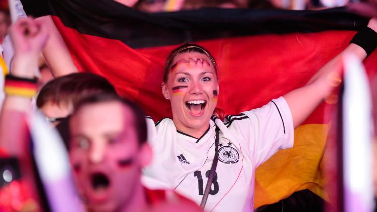 German soccer fans celebrate after their team scores at the Brazil World Cup semi final being played in Belo Horizonte, Brazil, between Germany and Brazil at a public viewing event called &#39;Fan Mile&#39; in Berlin, Tuesday, July 8, 2014. (AP Photo/Markus Schreiber)