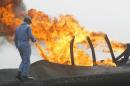A technician walks close to a flare at the Rumaila oilfield in southern Iraq, on January 19, 2010