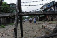 Muslim Rohingyas are seen walking towards a barbed wire fence along a road in the Aung Mingalar quarter, turned into a ghetto after violence wracked the city of Sittwe, capital of Myanmar's western Rakhine state, on October 12. At least 56 people have been killed and thousands of homes torched in a wave of fresh communal violence convulsing western Myanmar