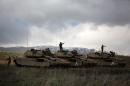 Israeli soldiers stand on alert on their Merkava tanks after being deployed on the border with Syria near the Druze village of Majdal Shams on March 19, 2014 in the Israeli-annexed Golan Heights