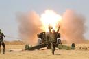 Popular Mobilization Forces (PMF) personnel fire artillery during clashes with Islamic State militants south of Mosul