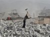 A worker smashes limestone inside a limestone mine in Quzhou, Zhejiang province
