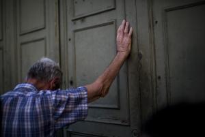 A pensioner leans against the main gate of the national &hellip;
