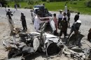 Afghans look at the wreckage of a vehicle after a roadside explosion on the outskirts of Laghman province east of Kabul, Afghanistan, Sunday, Aug. 12, 2011. A provincial spokesman says a roadside bomb has killed a district chief in eastern Afghanistan and three of his bodyguards. (AP Photo/Rahmat Gul)