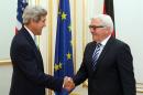 U.S. Secretary of State John Kerry, left, shakes hands with German Foreign Minister Frank-Walter Steinmeier, right, at a hotel where closed-door nuclear talks take place in Vienna, Austria, Sunday, July 13, 2014. Kerry meets separately with Steinmeier to discuss a spiraling espionage dispute between the close NATO partners. (AP Photo/Ronald Zak)