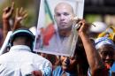 A woman holds a picture of Karim Wade at a meeting of the opposition on February 4, 2015 at the Place de l'Obelisque in Dakar