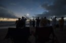 In this photo released by Tourism Queensland, people gather on Palm Cove beach in Queensland state, Australia, to watch a total solar eclipse Wednesday, Nov. 14, 2012. Starting just after dawn, the eclipse cast its 150-kilometer (95-mile) shadow in Australia's Northern Territory, crossed the northeast tip of the country and was swooping east across the South Pacific, where no islands are in its direct path. (AP Photo/Tourism Queensland, Murray Anderson-Clemence) EDITORIAL USE ONLY