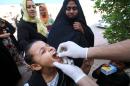 An Iraqi girl receives a dose of cholera vaccine at a camp in Basra on November 1, 2015