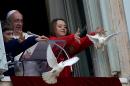 Children release white doves next to Pope Francis from the window of his private apartments during his Sunday Angelus prayer at St Peter's square on January 26, 2014 at the Vatican