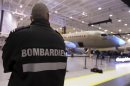 A security guard looks on as Bombardier unveils its CSeries aircraft at a news conference at its assembly facility in Mirabel, Quebec