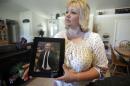 FILE - In this July 13, 2016 file photo, Laurie Holt holds a photograph of her son Joshua Holt at her home, in Riverton, Utah. Joshua Holt jailed in Venezuela since June has had his hopes for being reunited with his family for Christmas all but dashed with the fourth postponement of a preliminary hearing. Judge Elena Cassiani did not appear for a Tuesday, dec. 6, 2016 hearing, in which she was to rule on whether to dismiss the weapons charges against Holt. A new date was set for January. (AP Photo/Rick Bowmer, File)