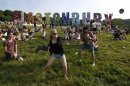 Festival goers play a game, batting a beer can with a wellington boot, on the first day of Glastonbury music festival at Worthy Farm in Somerset
