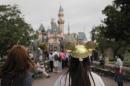 A woman with a Mickey Mouse hat walks toward Sleeping Beauty's Castle at Disneyland, Thursday, Jan. 22, 2015, in Anaheim, Calif. California public health officials urged those who haven't been vaccinated against measles to avoid Disney parks where a spreading outbreak originated. Seventy people have been infected. (AP Photo/Jae C. Hong)