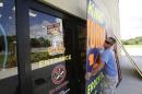 Andrew Esser boards up the glass doors at the entrance of Sky King Fireworks in preparation for Hurricane Matthew, Wednesday, Oct. 5, 2016, in Cocoa, Fla. (AP Photo/John Raoux)