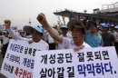 South Korean owners who run factories in the stalled South Korea and North Korea's joint Kaesong industrial complex and workers shout slogans during a rally insisting the normalize the operation of the industrial complex at the Imjingak Pavilion near the border village of Panmunjom, which has separated the two Koreas since the Korean War, in Paju, north of Seoul, South Korea, Wednesday, Aug. 7, 2013. About 500 owners and workers gathered near the border area for the rally. The letter read "Kaesong industrial complex is the symbol of two Koreas." (AP Photo/Lee Jin-man)