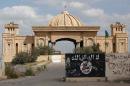 A general view taken on April 5, 2015 shows a defaced Islamic State group flag in front of the main gate of the palace of former Iraqi dictator Saddam Hussein in Tikrit after Iraqi forces retook the northern city from Islamist jihadists