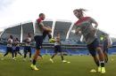 In this photograph taken with a fisheye lens, United States players warm up during an official training session the day before the group G World Cup soccer match between Ghana and the United States at the Arena das Dunas in Natal, Brazil, Sunday, June 15, 2014. (AP Photo/Julio Cortez)