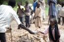 A young refugee from Blue Nile hands water to her father in Yusuf Batil in South Sudan on June 20, 2012