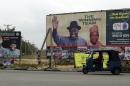 A taxi tricycle drives past campaign billboards displayed along a street in Otuoke, the home town of then Nigerian President and presidential candidate of the ruling People's Democratic Party Goodluck Jonathan in Bayelsa State, on January 27, 2015