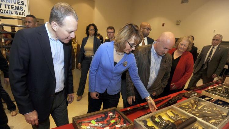 New York Attorney General Eric Schneiderman, left, former Arizona congresswoman Gabrielle Giffords, center, and her husband Mark Kelly tour the New EastCoast Arms Collectors Associates arms fair in Saratoga Springs, N.Y. on Sunday, Oct. 13, 2013. (AP Photo/Tim Roske, Pool)
