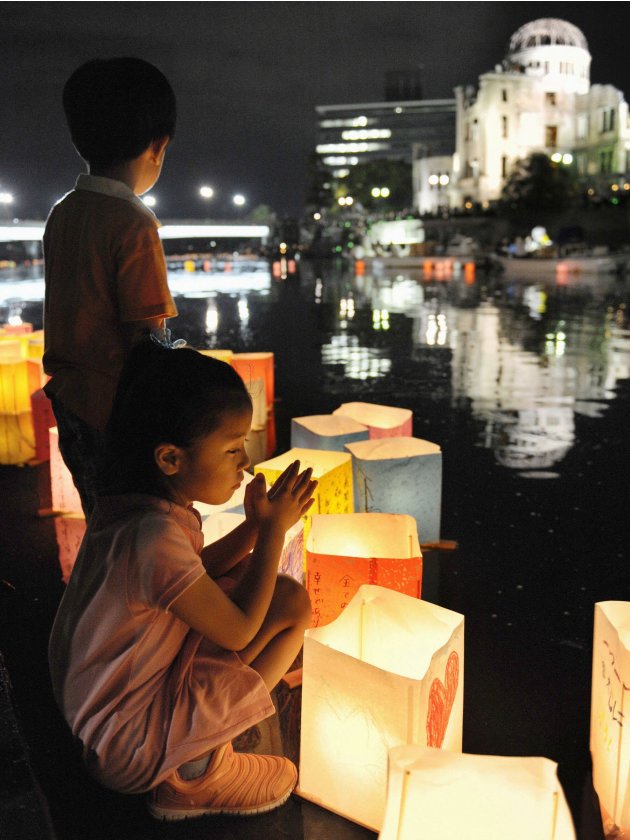 Girl prays after releasing paper lantern on Motoyasu river in remembrance of atomic bomb victims on 67th anniversary of bombing of Hiroshima