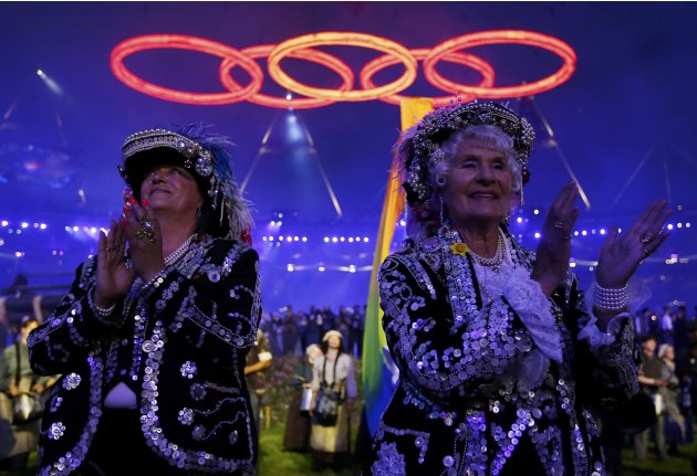 Performers clap as the Olympic rings are seen above, during the opening ceremony of the London 2012 Olympic Games at the Olympic Stadium